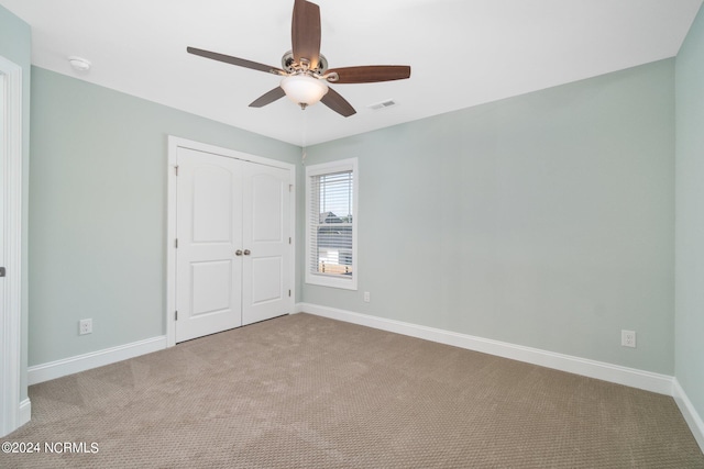 unfurnished bedroom featuring a closet, ceiling fan, and carpet