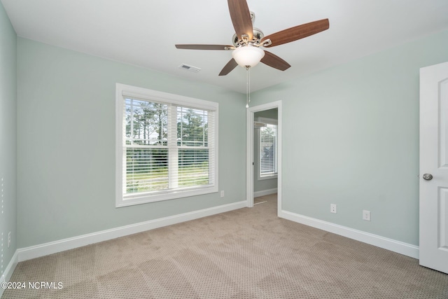 carpeted spare room with ceiling fan