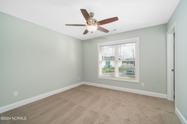 unfurnished room with ceiling fan and light carpet