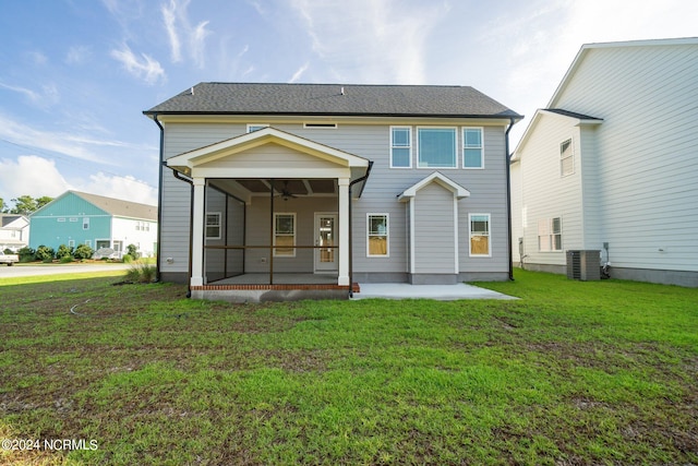 rear view of house featuring a lawn and central AC