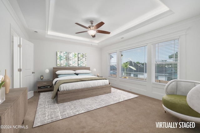 bedroom with ceiling fan, a raised ceiling, and carpet floors