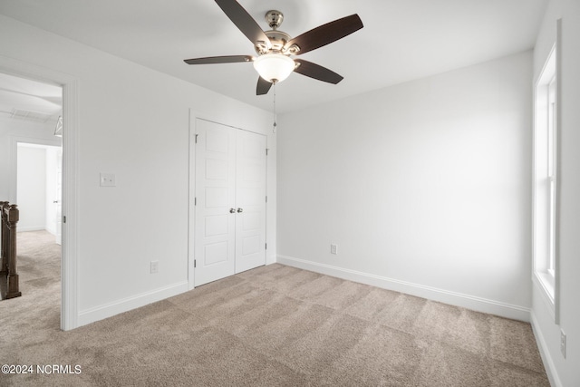 unfurnished bedroom featuring a closet, ceiling fan, and light carpet