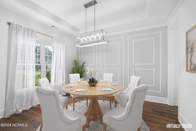 dining area featuring ornamental molding, a tray ceiling, and dark hardwood / wood-style floors