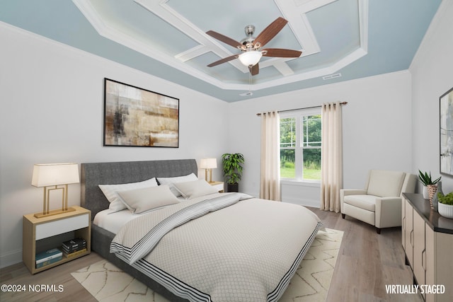 bedroom with coffered ceiling, crown molding, ceiling fan, a raised ceiling, and hardwood / wood-style flooring