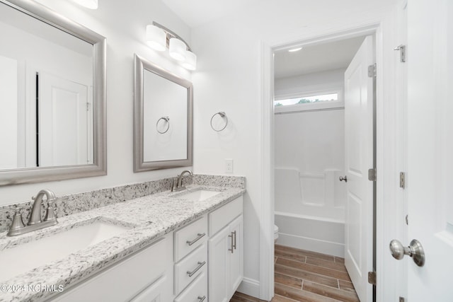 bathroom with vanity, toilet, and hardwood / wood-style floors