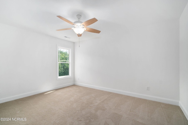 carpeted spare room featuring ceiling fan