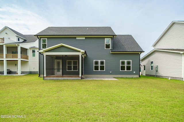 back of house with a patio, a shingled roof, a lawn, and a sunroom