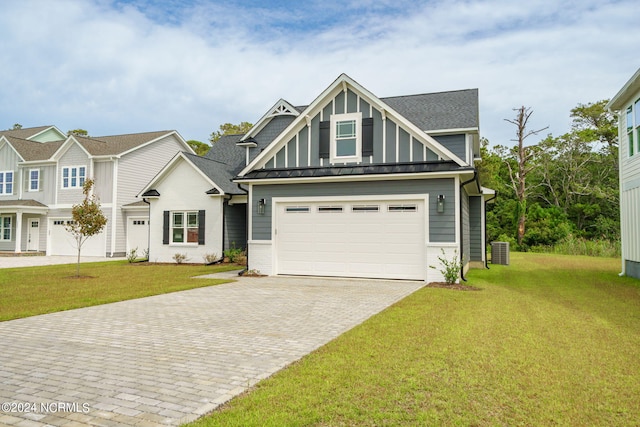 view of front facade featuring cooling unit, a front lawn, and a garage