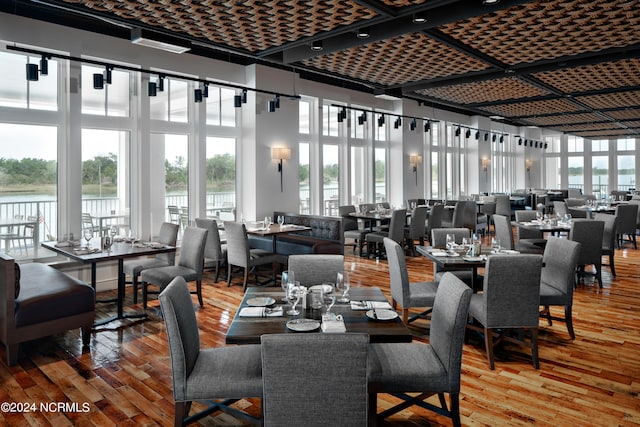 dining space with hardwood / wood-style floors and a water view