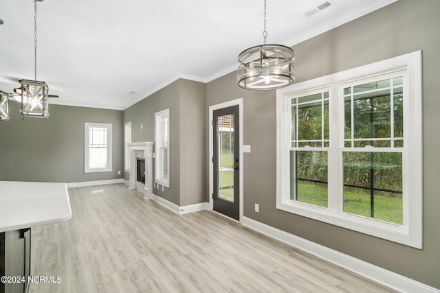 entryway with a notable chandelier, light hardwood / wood-style floors, and crown molding