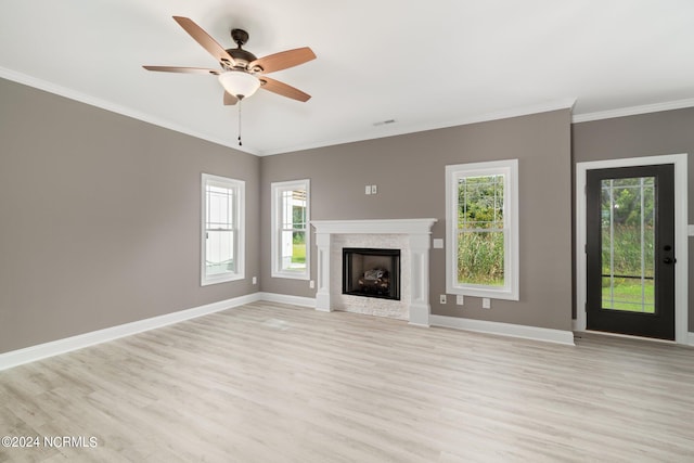 unfurnished living room featuring ceiling fan, crown molding, light hardwood / wood-style flooring, and a high end fireplace