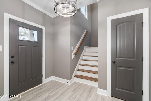 entrance foyer featuring crown molding, light hardwood / wood-style floors, and a chandelier