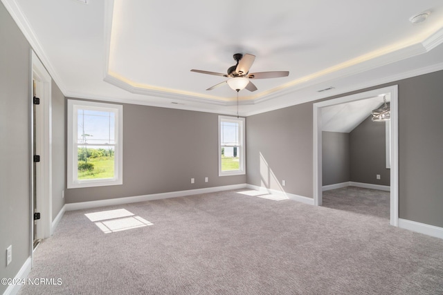 unfurnished bedroom with carpet floors, a tray ceiling, ornamental molding, a ceiling fan, and baseboards