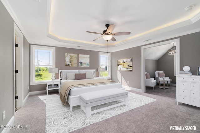 bedroom with ceiling fan, a raised ceiling, crown molding, and carpet flooring