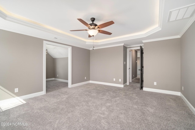 carpeted spare room featuring ceiling fan, crown molding, and a tray ceiling