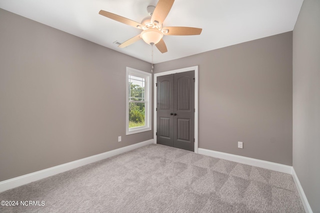 carpeted empty room featuring ceiling fan