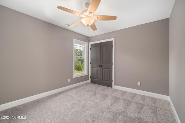 empty room featuring carpet, ceiling fan, and baseboards