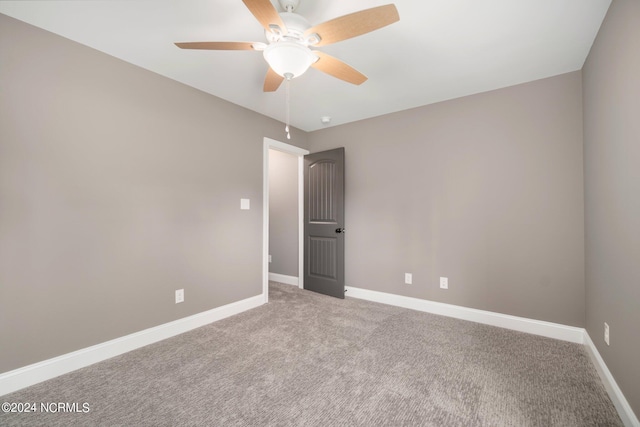 unfurnished room with a ceiling fan, carpet, and baseboards