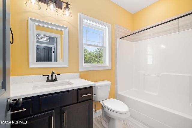 bathroom with washtub / shower combination, vanity, and toilet