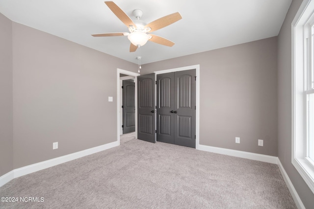 unfurnished bedroom with carpet floors, a closet, ceiling fan, and baseboards