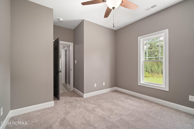 empty room featuring ceiling fan and light carpet