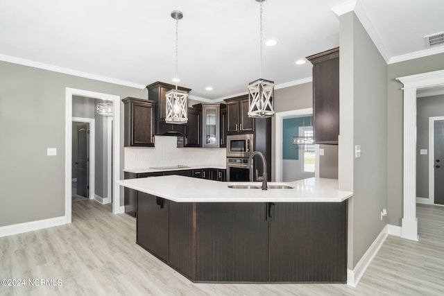 kitchen with backsplash, sink, ornamental molding, appliances with stainless steel finishes, and light hardwood / wood-style floors