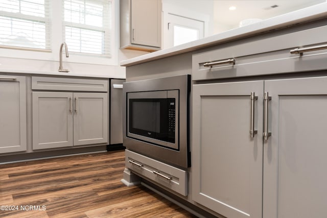 kitchen featuring stainless steel microwave, gray cabinets, and dark hardwood / wood-style floors