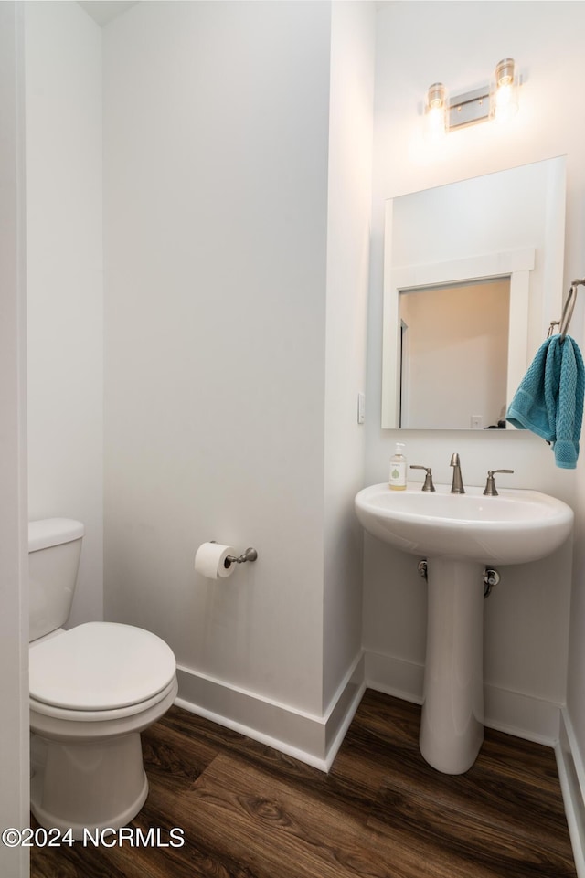 bathroom with hardwood / wood-style floors and toilet