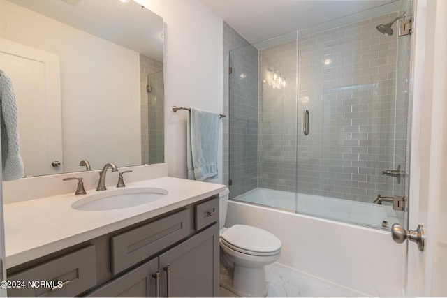 full bathroom with toilet, vanity, and bath / shower combo with glass door