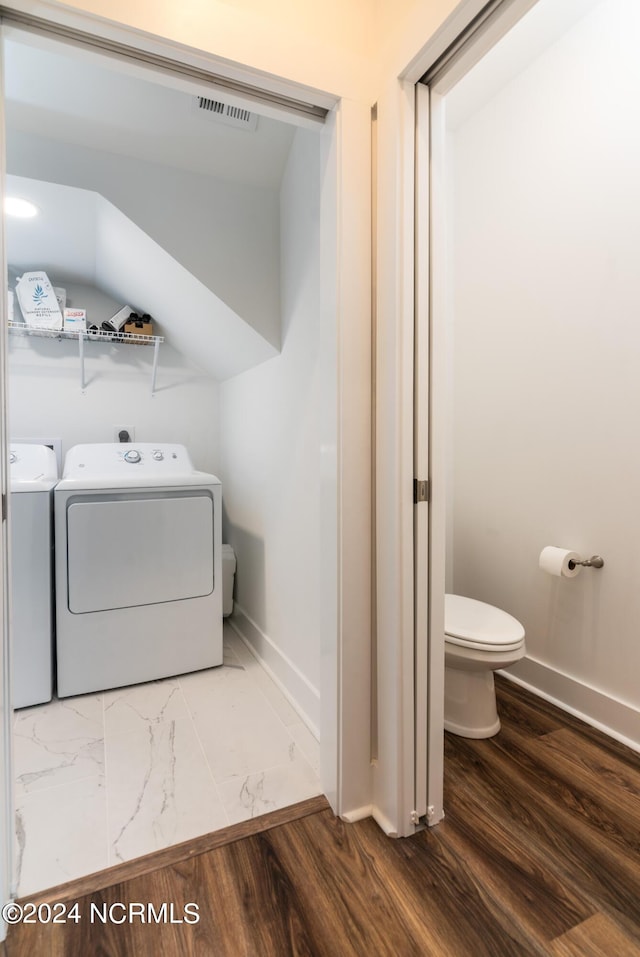 clothes washing area with independent washer and dryer and wood-type flooring