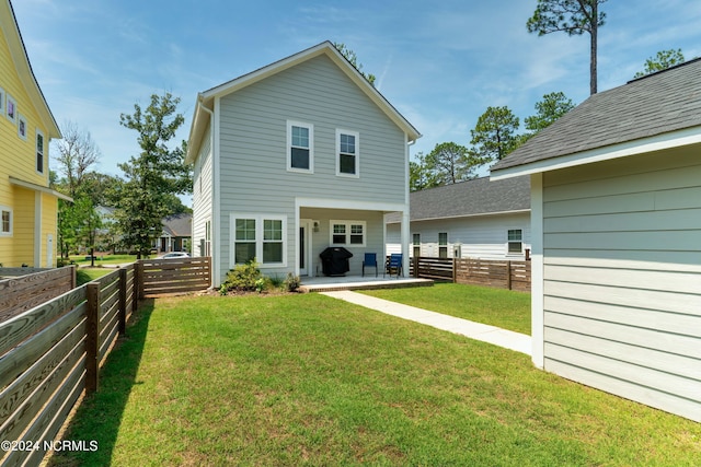 rear view of house featuring a yard and a patio