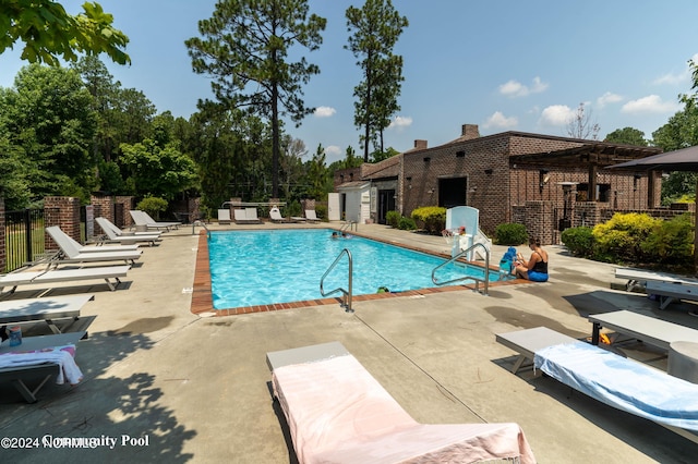 view of swimming pool with a pergola and a patio