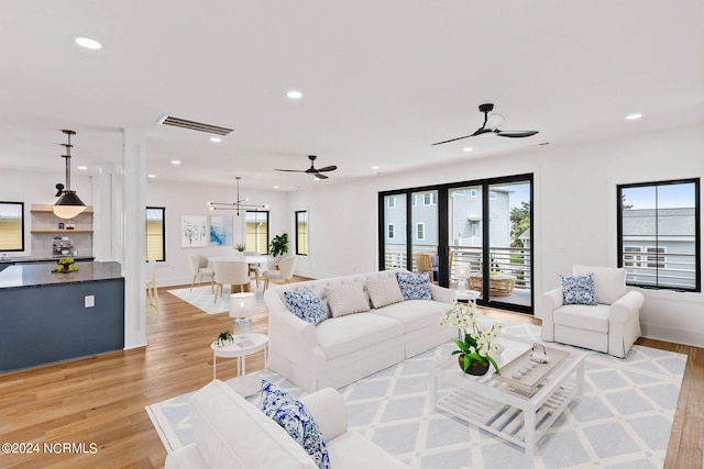 living room with light hardwood / wood-style flooring and ceiling fan