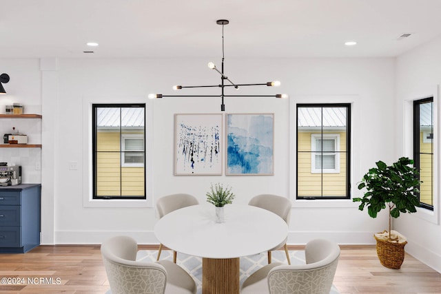 dining area featuring a notable chandelier and light hardwood / wood-style flooring