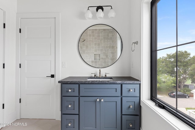 bathroom featuring vanity, a healthy amount of sunlight, and tile patterned flooring