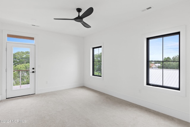 spare room featuring light carpet and ceiling fan