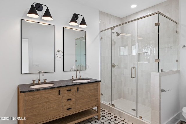 bathroom featuring walk in shower, tile patterned flooring, toilet, and double sink vanity