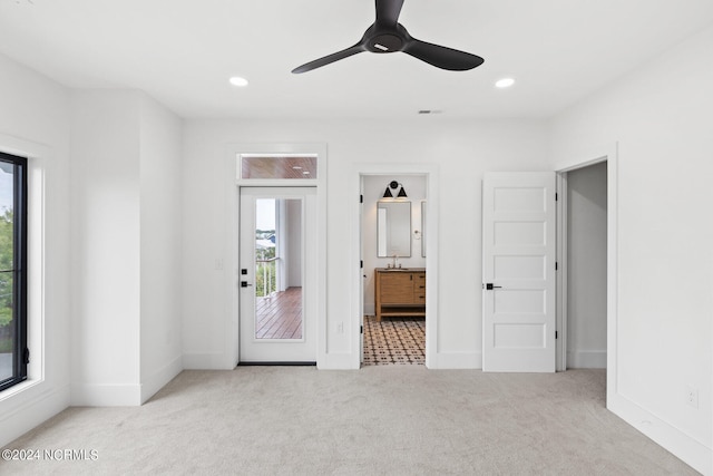 unfurnished bedroom with multiple windows, ceiling fan, and light colored carpet