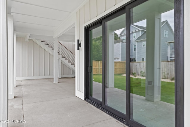 doorway to outside featuring beamed ceiling