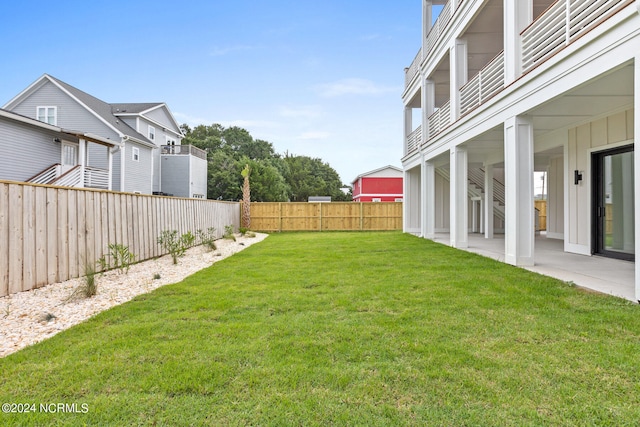 view of yard with a balcony and a patio