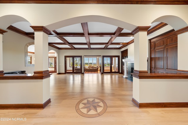 unfurnished living room with french doors, light hardwood / wood-style floors, coffered ceiling, and ornate columns