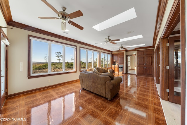 living room with crown molding, ceiling fan, a skylight, and tile patterned flooring