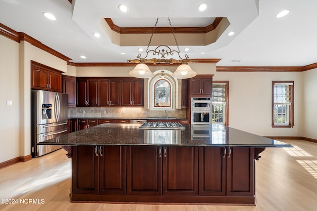 kitchen featuring crown molding, appliances with stainless steel finishes, pendant lighting, and backsplash