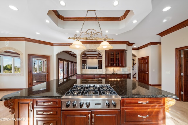 kitchen featuring ornamental molding, stainless steel gas stovetop, a center island, and hanging light fixtures