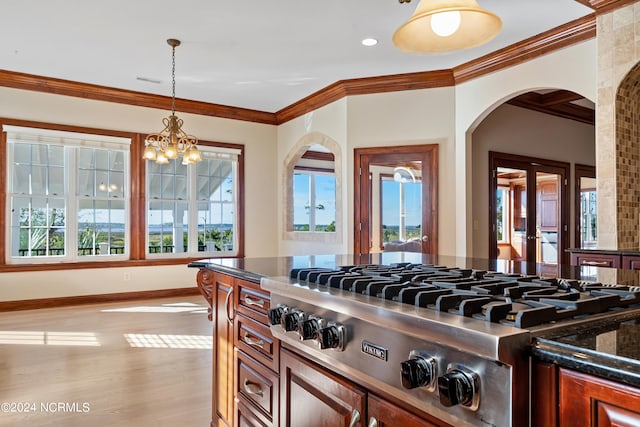 kitchen with stainless steel gas cooktop, light hardwood / wood-style flooring, ornamental molding, and hanging light fixtures