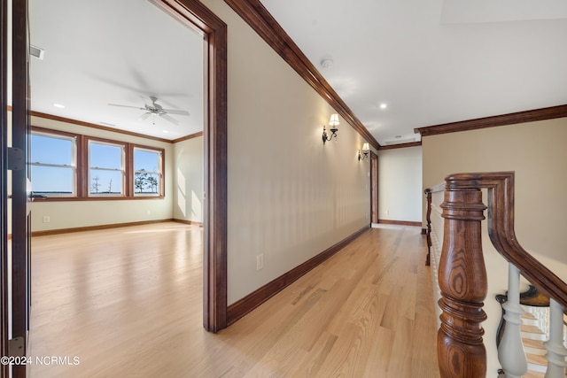 hallway with ornamental molding and light hardwood / wood-style flooring