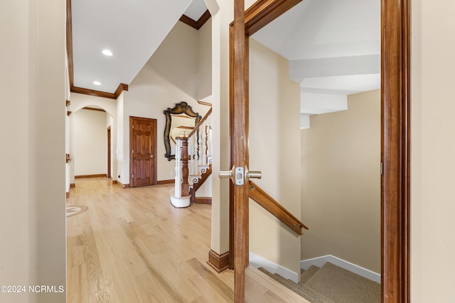 hallway featuring ornamental molding and light hardwood / wood-style floors