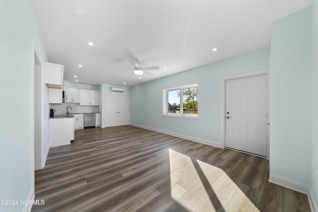 unfurnished living room with dark wood-type flooring, ceiling fan, and sink