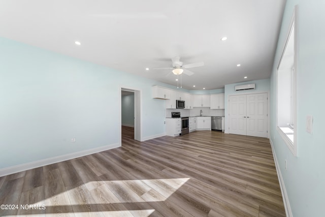 unfurnished living room featuring light hardwood / wood-style floors, sink, and ceiling fan