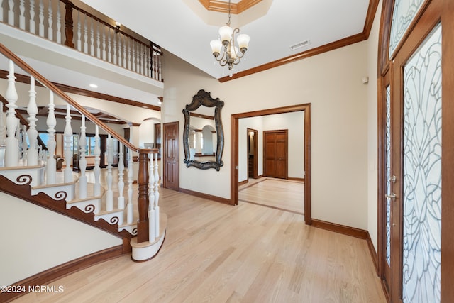 foyer with crown molding, a notable chandelier, and light hardwood / wood-style flooring